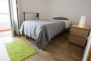 1 dormitorio con cama y alfombra verde en 1977, en Faro