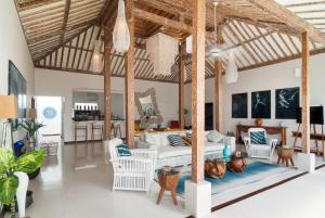 a living room with a bed and a kitchen at De'Coco Villa in Gili Air