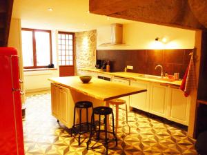 uma cozinha com balcão e bancos em Chez Henriette em Voiteur