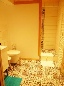 a bathroom with a tub and a toilet and a sink at Chez Henriette in Voiteur