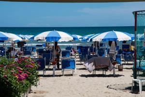 una spiaggia con sedie e ombrelloni blu e bianchi di B&B Teranga a Montecarotto