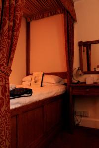 a bedroom with a canopy bed with a mirror at The Crown at Wells, Somerset in Wells