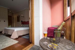 una habitación con una mesa con una copa de vino y un dormitorio en Hotel Puerta Del Oriente, en Tresgrandas