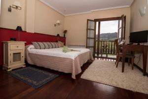 1 dormitorio con cama, escritorio y ventana en Hotel Puerta Del Oriente, en Tresgrandas
