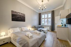 ソポトにあるDom & House - Apartments Podjazd Central Sopotの白いベッドルーム(ベッド1台付)、キッチンが備わります。
