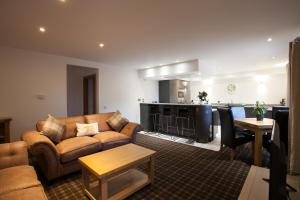 Una sala de estar con un sofá y una cocina. en Tower Ridge Apartments, en Fort William
