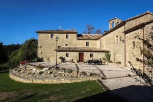 un gran edificio de piedra con un patio con rocas en Valbuona b&b en Mercatello sul Metauro