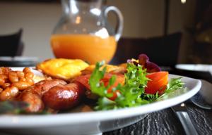 un plato de comida con salchichas y verduras en una mesa en Mondior Manor Guest House en Kimberley