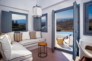 a living room with a couch and two windows at Alunia Incognito Suites - Adults Only in Pyrgos