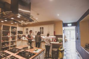 a group of people standing in a kitchen at The Black Sheep Hostel in Killarney