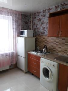 cocina con lavadora y microondas en Apartment Prem'yer, en Cherkasy