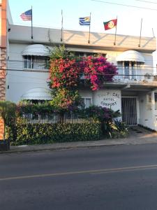 un edificio blanco con flores a un lado en REDE BONNEL 88 Confort, en Cachoeira do Sul