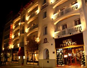 um grande edifício com árvores de Natal em frente em Hotel Pyrénées em Andorra-a-Velha