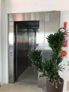 an elevator with a potted plant in front of it at Hotel Pousada Santos in Pinheiro