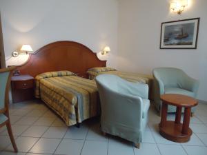 pokój hotelowy z łóżkiem i dwoma krzesłami w obiekcie Albergo Roma w mieście Casciana Terme +25 zdjęć