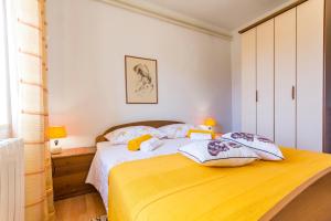 ein Schlafzimmer mit einem Bett mit einer gelben Decke in der Unterkunft Apartment Lori in Fažana