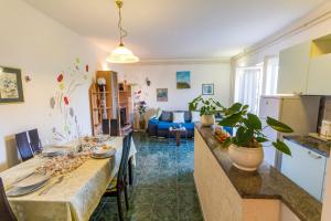 eine Küche und ein Wohnzimmer mit einem Tisch und einem Sofa in der Unterkunft Apartment Lori in Fažana