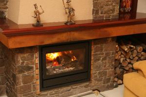 a brick fireplace with a fire in it at Hotel Pyrénées in Andorra la Vella