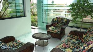 a living room with chairs and a couch and a stool at Hotel Bonnel Confort - Rede Bonnel Tropical in Cachoeira do Sul