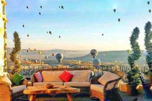 a living room with a couch and hot air balloons at La Casa Cave Hotel in Uçhisar