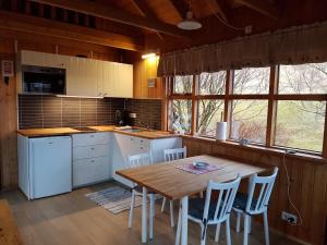 a kitchen with a wooden table and some chairs at Ásólfsskáli Cottage in Ásólfsskáli