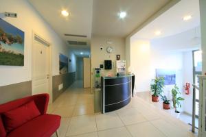 an office lobby with a refrigerator and a red chair at B&B Al Picchio in Monopoli