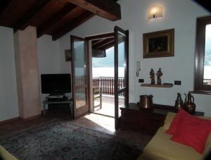 a living room with a couch and a television at Appartamento monteisola mara in Monte Isola