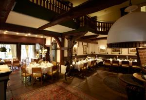 a dining room with tables and chairs and a staircase at Forsthaus Heiligenberg in Bruchhausen-Vilsen