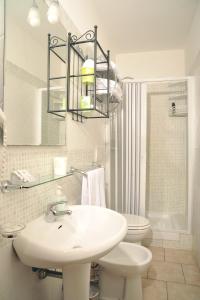 Un baño blanco con lavabo e inodoro. en Locanda al Viminale, en Roma 62 fotos más