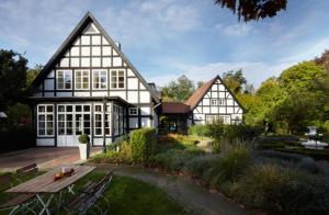 a large black and white house with a garden at Forsthaus Heiligenberg in Bruchhausen-Vilsen