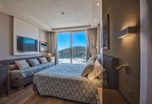 a hotel room with a bed and a couch at Villa Margherita Wellness & Golf - "Your Private Punta Ala" in Punta Ala