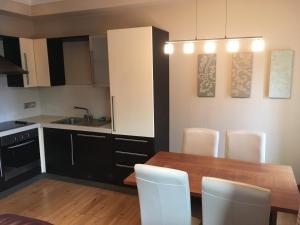 a kitchen with a wooden table and white chairs at Beautiful Killarney Apartment in Killarney