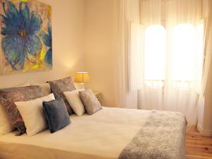 una camera da letto con un letto grande con cuscini di Sado Blue - City&River Flats by be@home a Setúbal