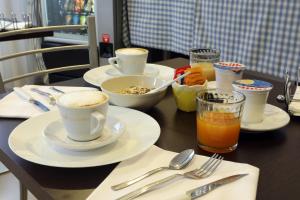 a table with cups and plates of food and drinks at B&B Al Picchio in Monopoli
