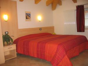 una camera con un letto con una coperta rossa di Hotel Victory a Taio