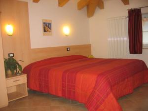a bedroom with a bed with a red blanket at Hotel Victory in Taio
