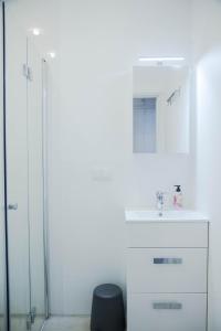 y baño con lavabo y ducha acristalada. en Apartament w centrum Gdyni, en Gdynia