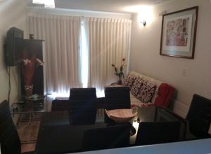 - un salon avec des chaises, un canapé et une télévision dans l'établissement Bosque Nevado, à Nevados de Chillan