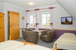 1 Schlafzimmer mit 2 Betten, einem Tisch und Stühlen in der Unterkunft Landgasthof Fegetasch in Neukirchen