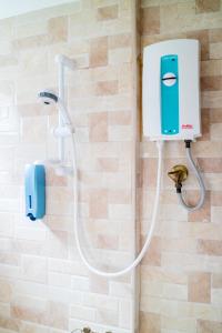 eine Dusche im Bad mit einem Seifenspender in der Unterkunft The Cube Sathorn Boutique Hotel เดอะ คิวบ์ สาทร บูติค โฮเทล Near BTS Surasak in Bangkok