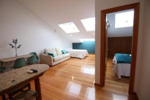 sala de estar con sofá y cama en Apartamentos Alda Porta do Sol en Vigo
