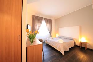 a bedroom with a bed and a vase of flowers on a table at B&B Al Picchio in Monopoli