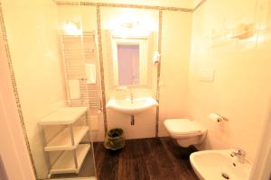a white bathroom with a sink and a toilet at B&B Al Picchio in Monopoli