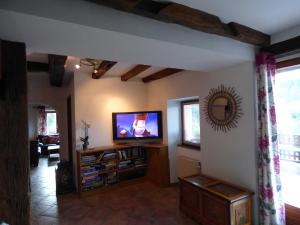 VilléにあるLes Cerisiersの壁に薄型テレビが取り付けられたリビングルーム