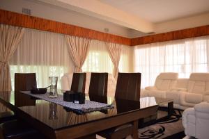 a living room with a table and white chairs at Moye Guest House in Benoni +136 photos