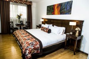 ein Schlafzimmer mit einem Bett und einem Tisch mit einem Nachttisch in der Unterkunft Hotel Mendoza in Mendoza