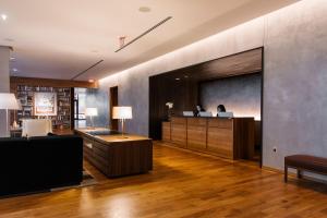 a lobby with a reception desk and a person on a screen at The Study at University City, Study Hotels in Philadelphia
