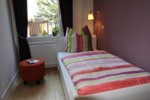 - un lit avec une couverture rayée dans une chambre avec une fenêtre dans l'établissement Tal-Residenz Erdgeschoss, à Bad Salzuflen