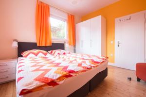 バート・ザルツフレンにあるTal-Residenz Erdgeschossのベッドルーム1室(オレンジ色のカーテン付きのベッド1台付)