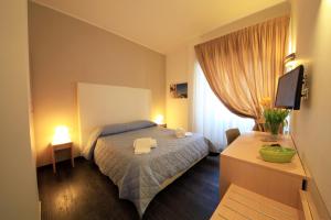 a bedroom with a bed and a tv and a window at B&B Al Picchio in Monopoli